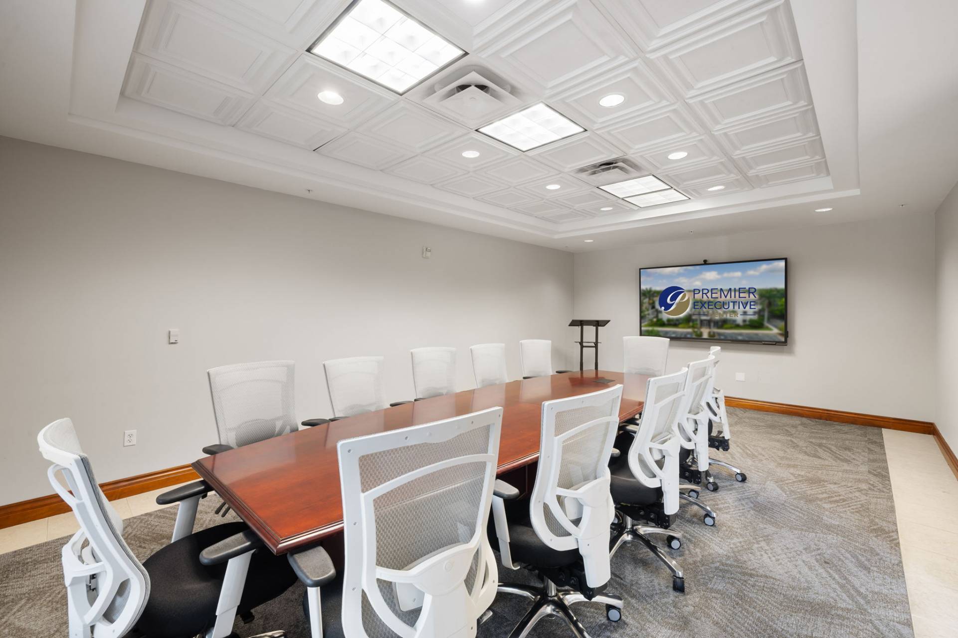 Second-floor conference room with 8-seat table, HDMI TV, VOIP phone, and private Wi-Fi. Fort Myers executive suites.