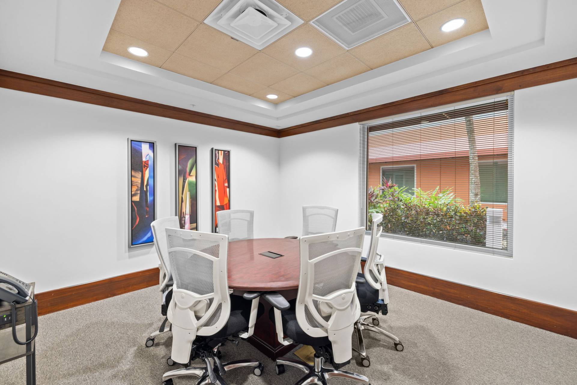 Fort Myers small boardroom with round table, 6 chairs, VOIP phone, Wi-Fi, and thermostat control.