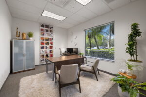 Naples FL show office with modern furniture, lush plants, and natural lighting in a professional workspace setting.