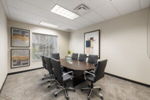 Second-floor conference room with 8-seat table, HDMI TV, VOIP phone, and private Wi-Fi. Naples executive suites.