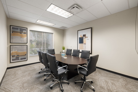 Second-floor conference room with 8-seat table, HDMI TV, VOIP phone, and private Wi-Fi. Naples executive suites.