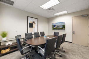 Second-floor conference room with 8-seat table, HDMI TV, VOIP phone, and private Wi-Fi – Naples executive suites.